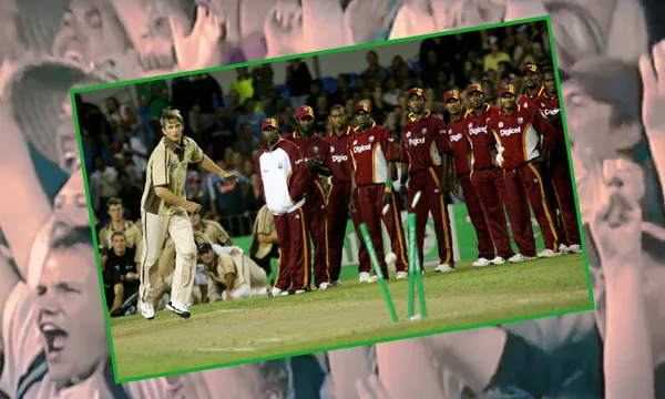 in the foreground, shane bond hits the wickets in a bowl off as the west indies players watch on. in the background, the crowd goes wild