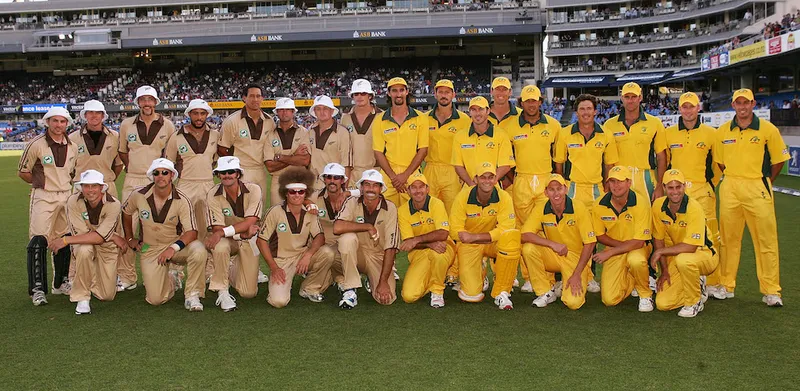 group photo of the black caps and australia teams before the first ever t20 international. nz in beige uniforms and white bucket hats, australia in yellow uniforms. several players who don't normally have a moustache have a moustache