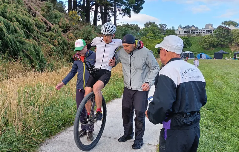 Supporters lift Ken Looi back onto his unicycle during the world record attempt.