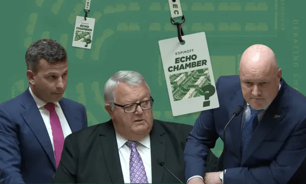 Three men in suits engaged in conversation stand in front of a green background featuring graphic badges labeled "ECHO CHAMBER.".
