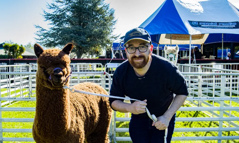 A photo of author Duncan Sarkies next to an alpaca.