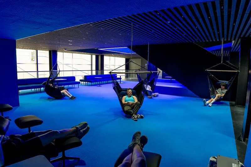 blue lit room with hammock and couches