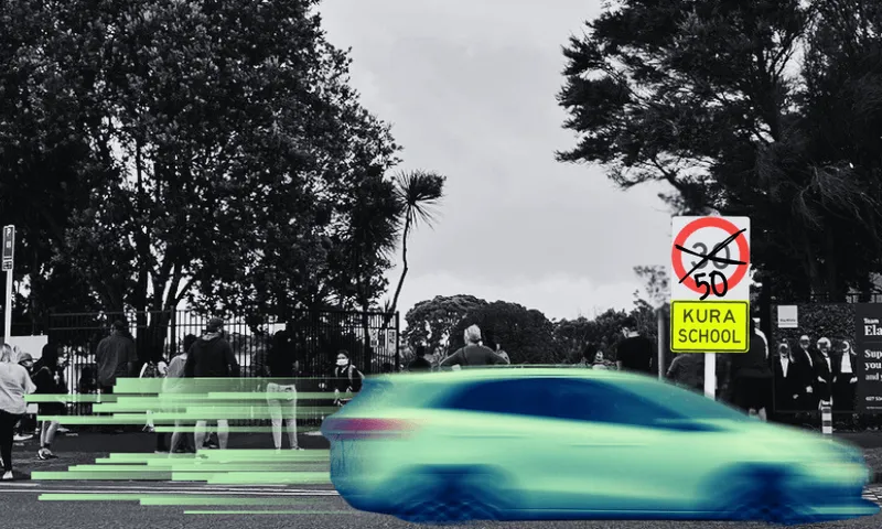 A digitally altered image shows a car speeding past a school zone sign that reads "Kura School," with a crossed-out 50, indicating reduced speed. The background has trees and a blurred group of people, emphasizing motion.