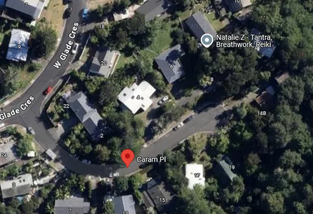 Aerial view of a residential area showing winding streets with houses surrounded by trees. Landmarks include locations labeled "Natalie Z - Tantra, Breathwork, Reiki" and "Caram Pl." Streets are curved and lined with greenery.