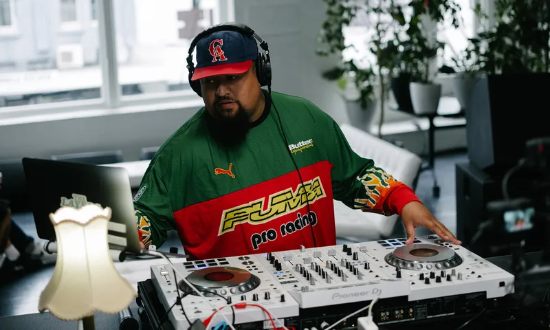 Man on a DJ deck wearing cap and headphones