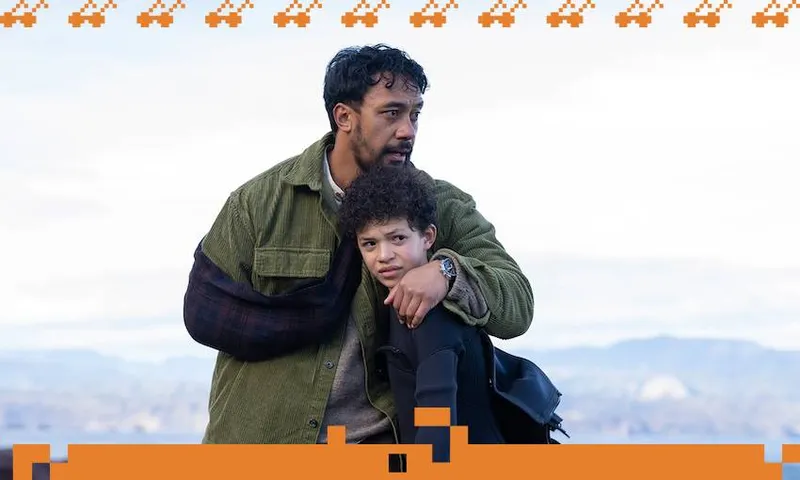In a scene from TV drama Secret at Red Rocks, A man wearing a green jacket hugs his son tightly as they stand on a beach and look into the distance