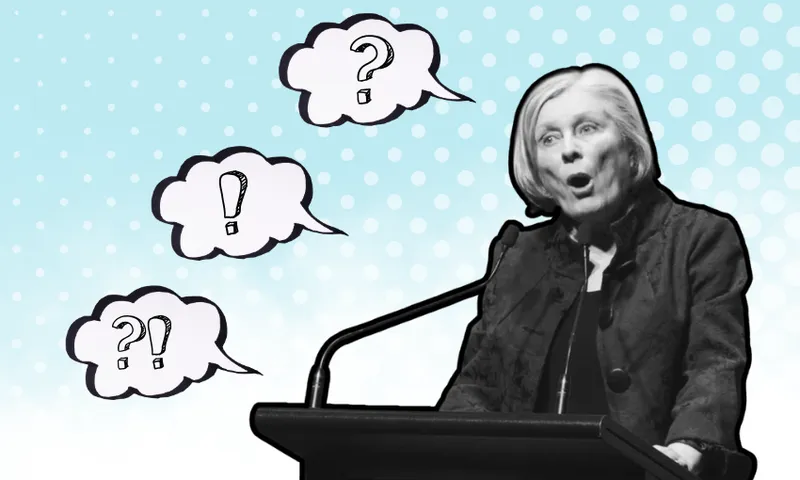 A woman speaking at a podium with a surprised expression. Four speech bubbles with question marks and exclamation points surround her. The background is a gradient blue with polka dots. The image is in black and white.