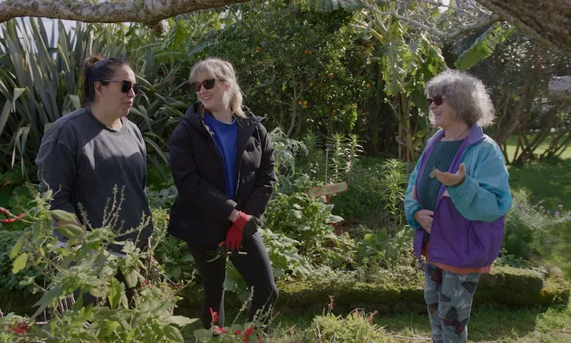 bryn and ku chat to an older woman in a garden