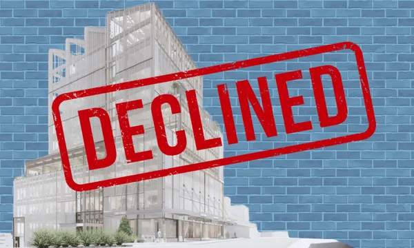 A modern building design with a large red "DECLINED" stamp over it, set against a blue brick wall background.