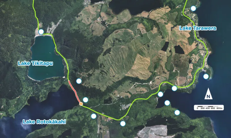 Aerial map showing three lakes: Lake Tikitapu, Lake Rotokākahi, and Lake Tarawera. A green route connects them, with a red section highlighting a particular area. North arrow and a scale bar are present. Forested areas and fields are visible.
