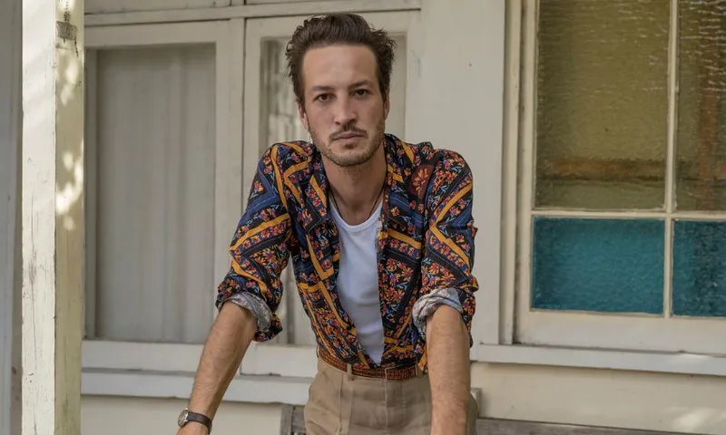 Marlon Williams leans against a railing in an editorial photo shoot