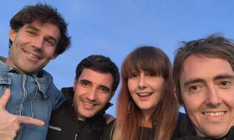 A photo of four people at twilight.
