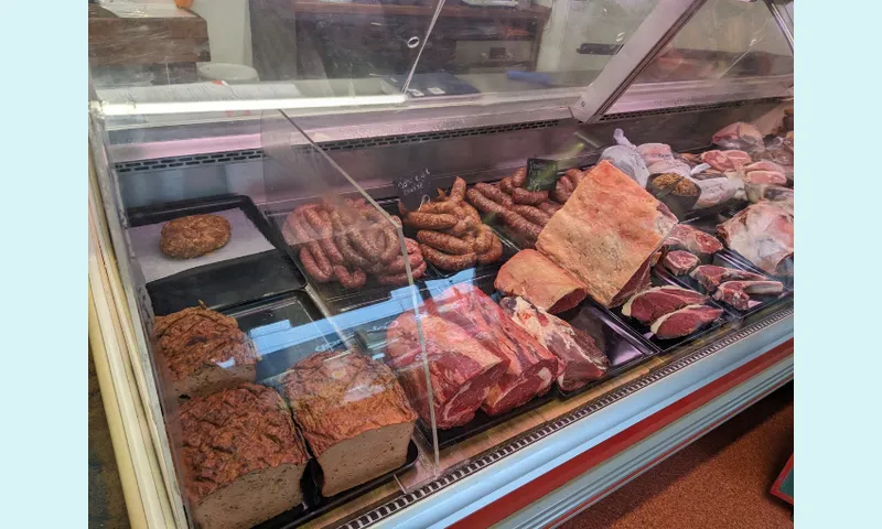 a selection of meat in somewhat sallow lighting, marbled meatloaf and bits of bacon