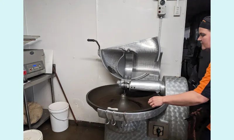 a shining silver machine with willert checking on it by leaning over the scoopy bowl