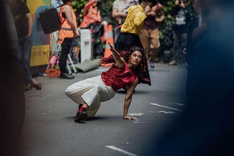 person in red top dancing on the pavement