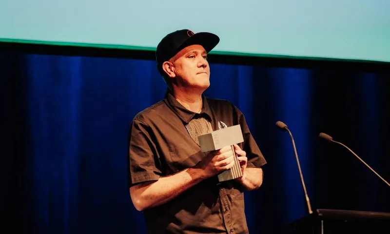 Mokotron accepts his Taite award on stage.
