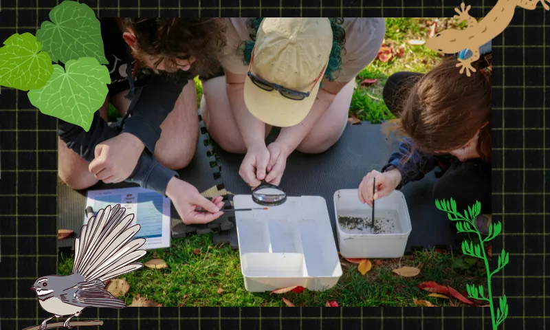 a group of young people with magnifying glasses around a tray with water and soil in it