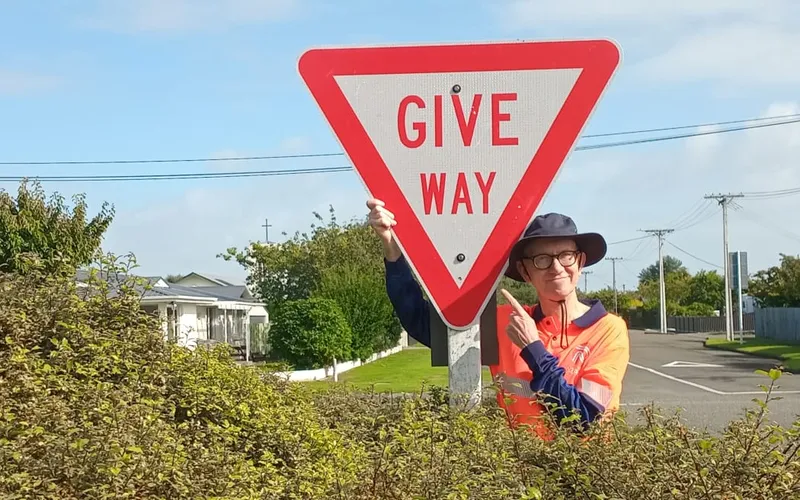 man with a giveway road sign