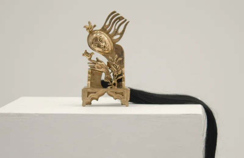 small bronze sculpture with face, birds
