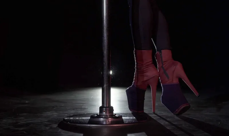 Pole dance. Young beautiful caucasian brunette woman dancer in studio