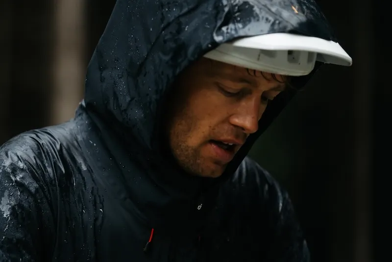ben hildred looks a bit bleak in a black raincoat with a somber expression on his face
