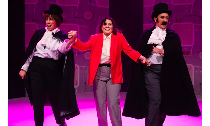 A photograph of one woman in a red jacket flanked by two actors dressed like Dracula.