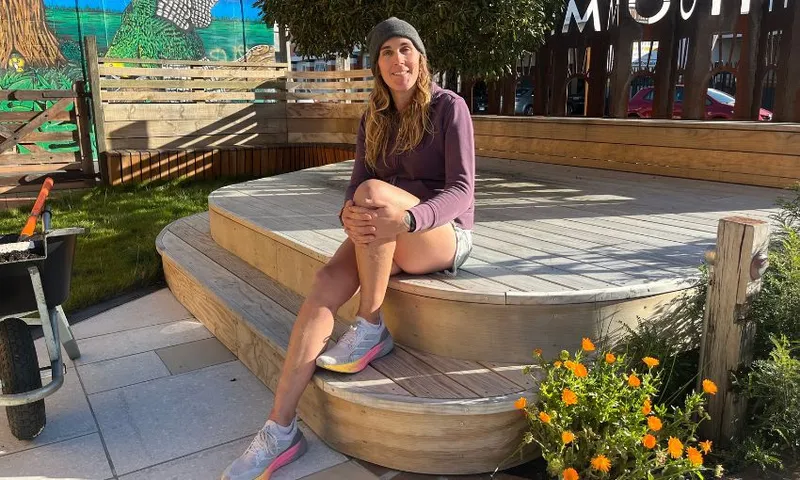 Cahoots founder Jade Musther sits on a platform outside her workshop in the sun.
