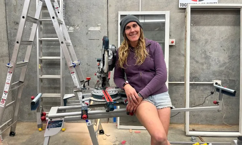 Cahoots' Jade Musther leans against a table saw in her workshop.