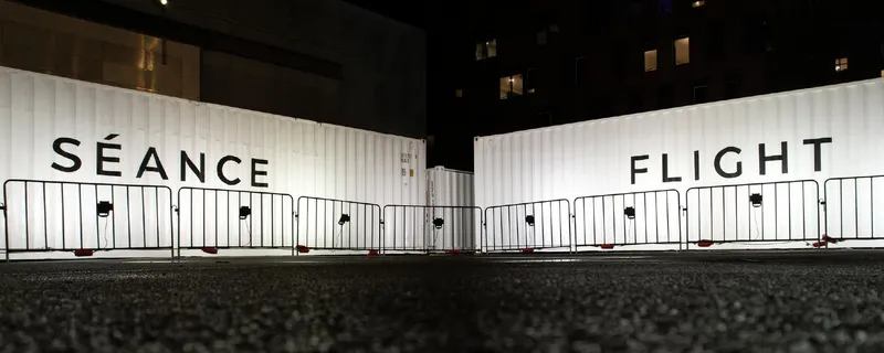 two white shipping containers in a dark square
