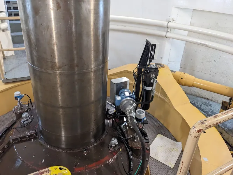 a steel pipe in theh ydro station with hydraulic systems around it to control the water