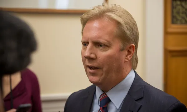 a blone man in the halls of parliament wearing a suit