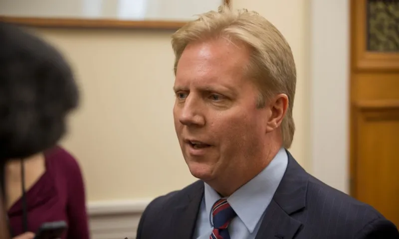 a blone man in the halls of parliament wearing a suit