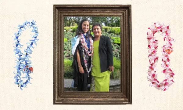 a framed photo on a wall showing a mother and daughter posing, the daughter wearing graduation regalia and the mother wearing traditional samoan dress