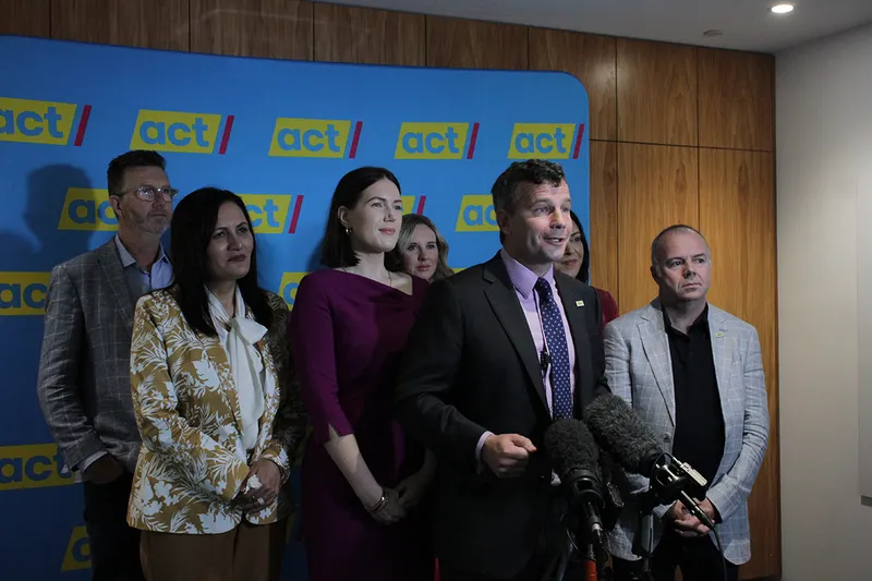 group of people headed by david seymour in front of Act Party banner
