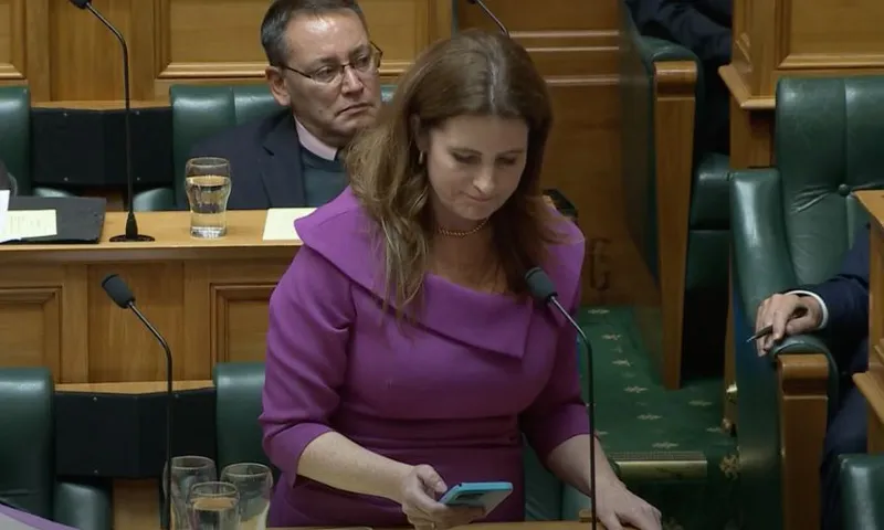 Nicola Willis looks at her phone while correcting herself in the House of Representatives.