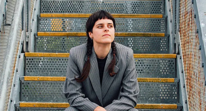 photo of a young woman sitting on industrial stairs