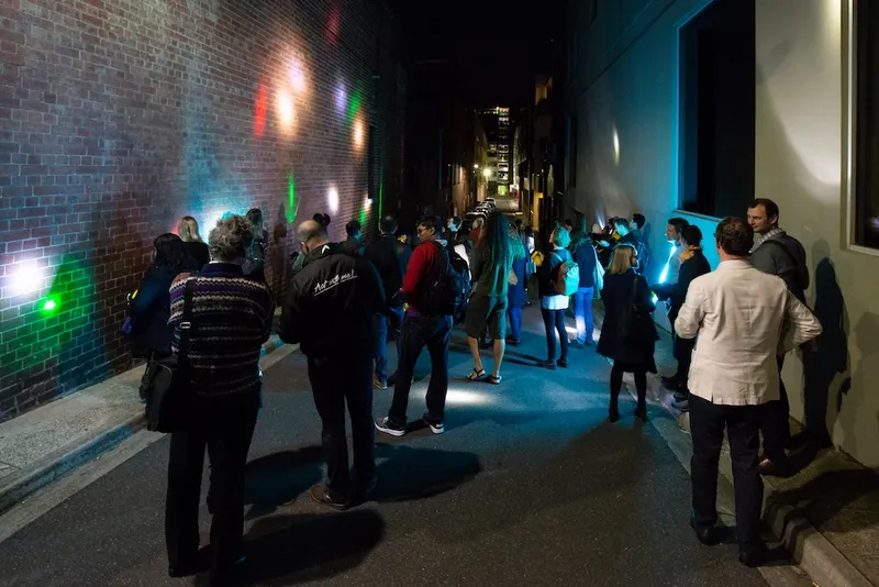 a group of people shining lights at the wall