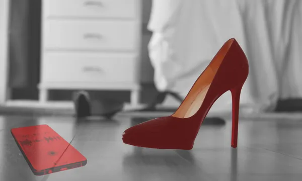 A red high-heeled shoe and a red smartphone with a visible sound recording screen are in focus on a bedroom floor, with a dresser and blurred clothing in the background.