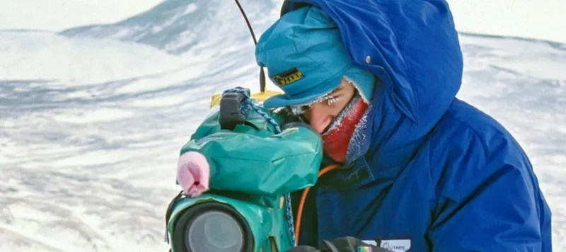 man with big camera in snow