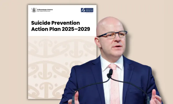 A man in a suit and tie speaks at a podium in front of a large document titled "Suicide Prevention Action Plan 2025–2029" with New Zealand government logos.