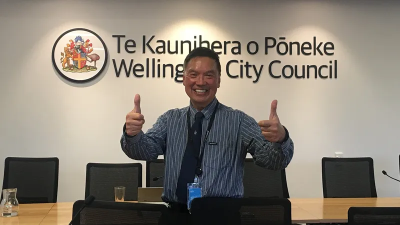 A man standing in a board room with two thumbs up