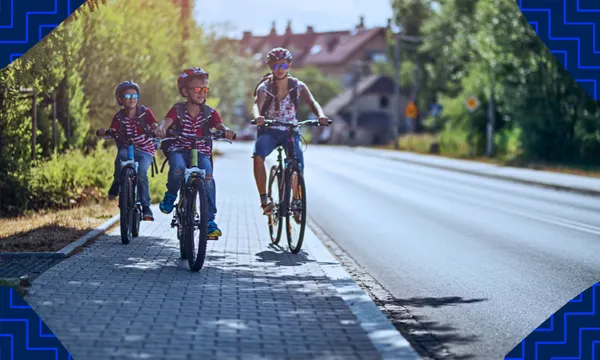 Three kids riding on a footpath, with blue zigzaggy borders
