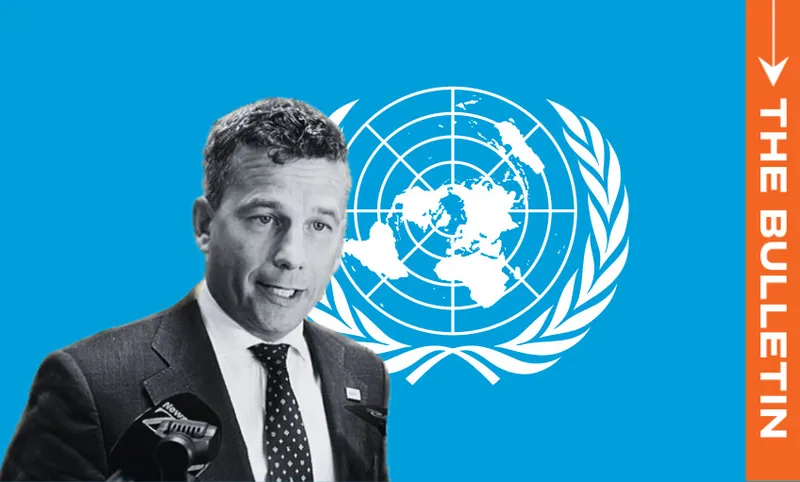 A man in a suit speaks at a microphone, with the United Nations emblem behind him on a blue background. An orange vertical banner on the right reads "THE BULLETIN" in white text.