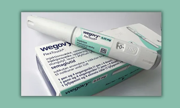 a white pen-shaped medication with green stickering and a green and white medicine box