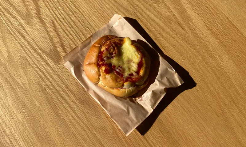 a round pizza bread on a brown bag in a wooden table