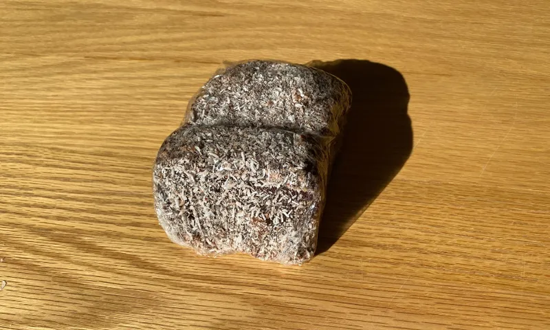 a chocolate lamington on a wooden table