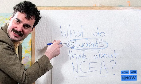 A man points to the words “What do students think about NCEA?” written on a whiteboard, with “students” circled. A blue “Now You Know” logo appears in the bottom right corner.