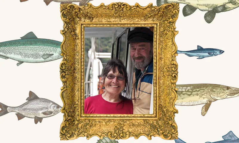 A photo of writer and activist Ruth Shaw with her husband Lance, on their boat. Fish wallpaper design is behind them.