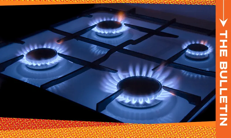 Four gas stove burners are lit with blue flames on a black stovetop. The right edge of the image features an orange vertical banner with the text "THE BULLETIN.