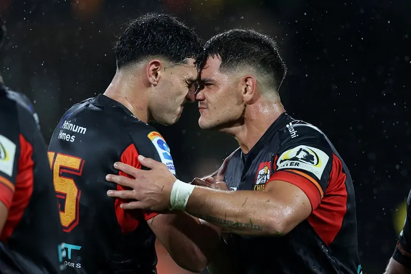 two men with shirt hair and wearing rugby uniforms press noses